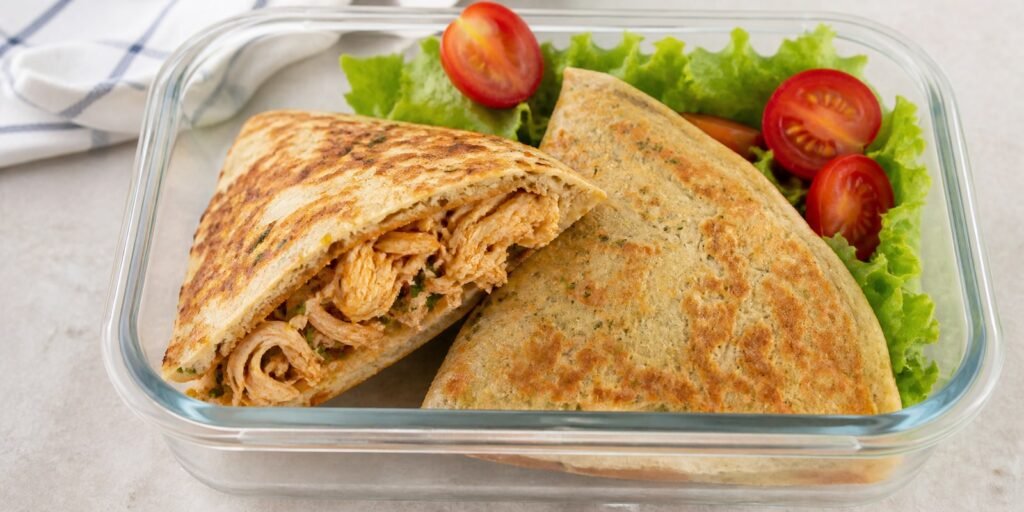 Panqueca de aveia recheada com frango desfiado cortada em um pote de vidro